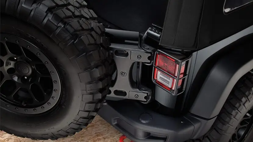 Close-up of a rugged off-road vehicle's rear tire and taillight assembly.