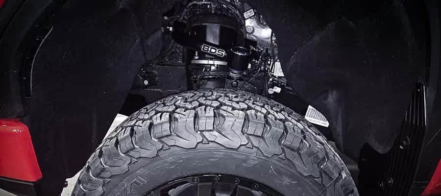 Close-up of a vehicle's lifted suspension with a BDS strut and off-road tire.